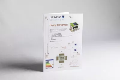 A printed Christmas card design featuring a green and white color scheme with product packaging illustrations, technical specifications, and energy efficiency ratings displayed on a white background.